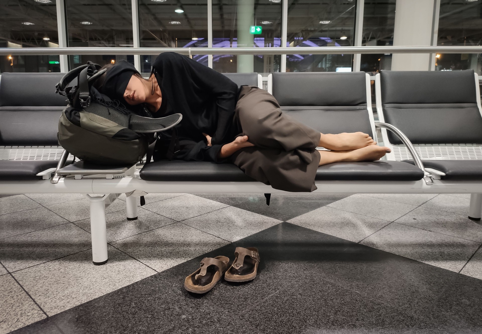 Woman Sleeping On Bench At Airport