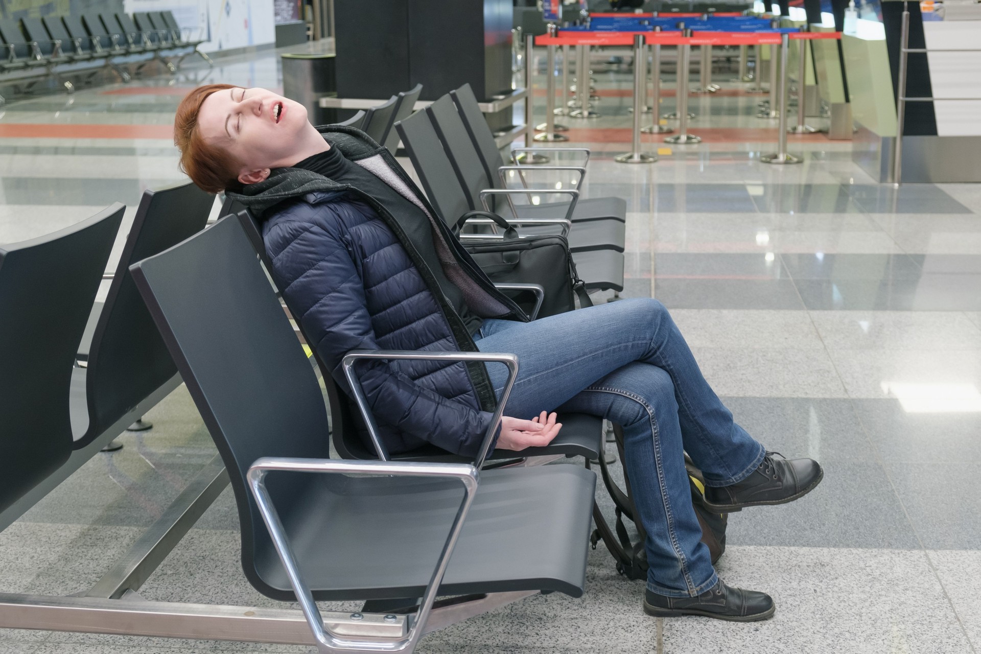 Woman sleeps with her mouth open in the departure area of an international airport